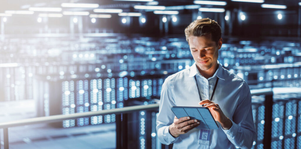 A man in a data centre looking at a tablet